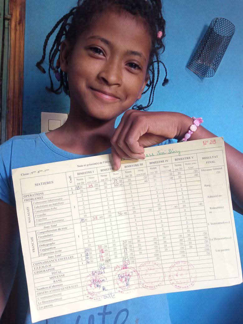Enfant montrant son bulletin de note